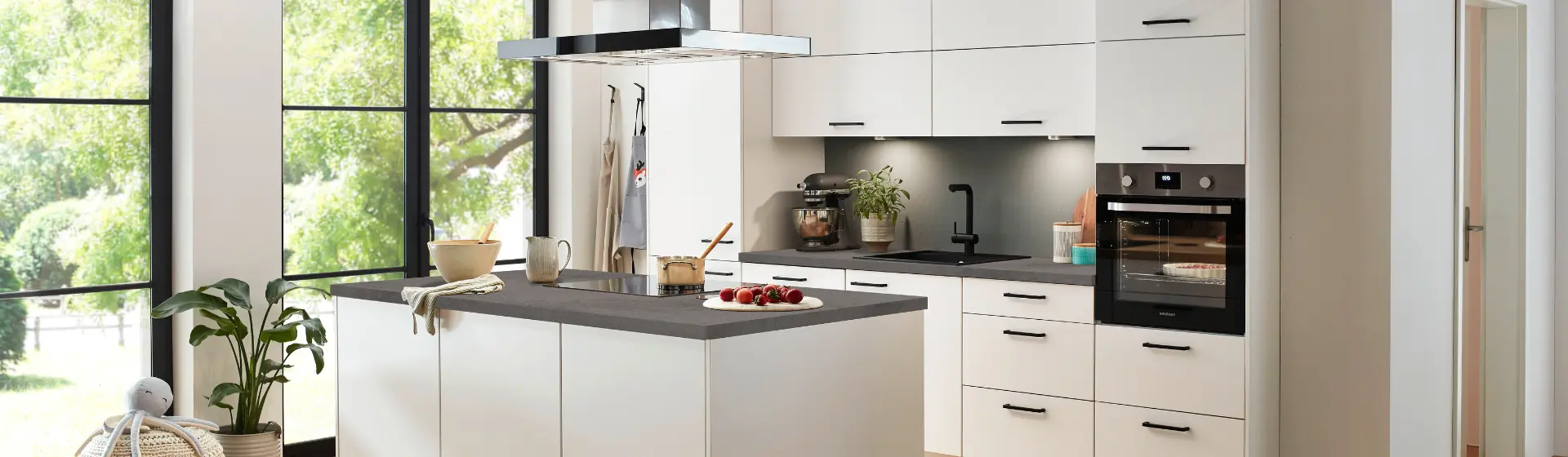 Moderne Küche mit weißen Schränken, einer grauen Arbeitsinsel und Geräten aus Edelstahl Moderne Küche mit weißen Schränken, einer grauen Arbeitsinsel und Geräten aus Edelstahl